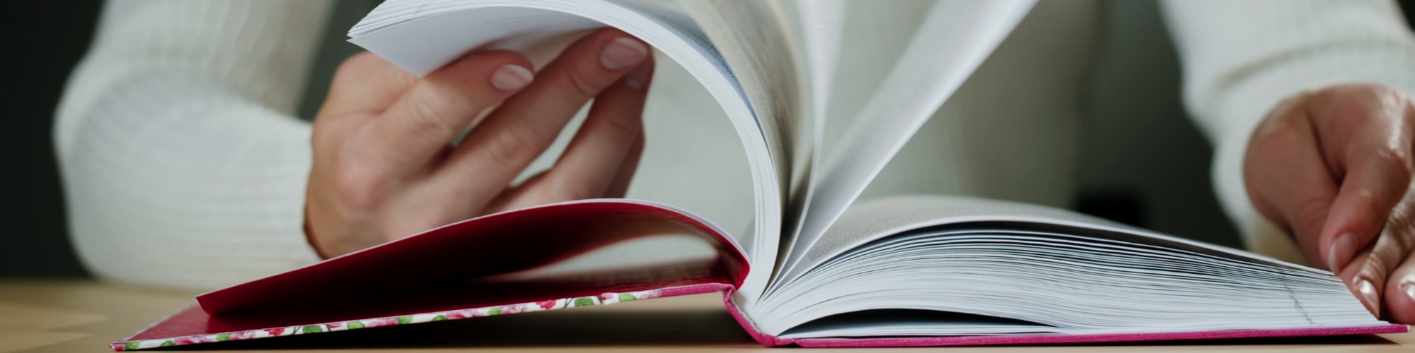 woman flipping through spanish textbook.