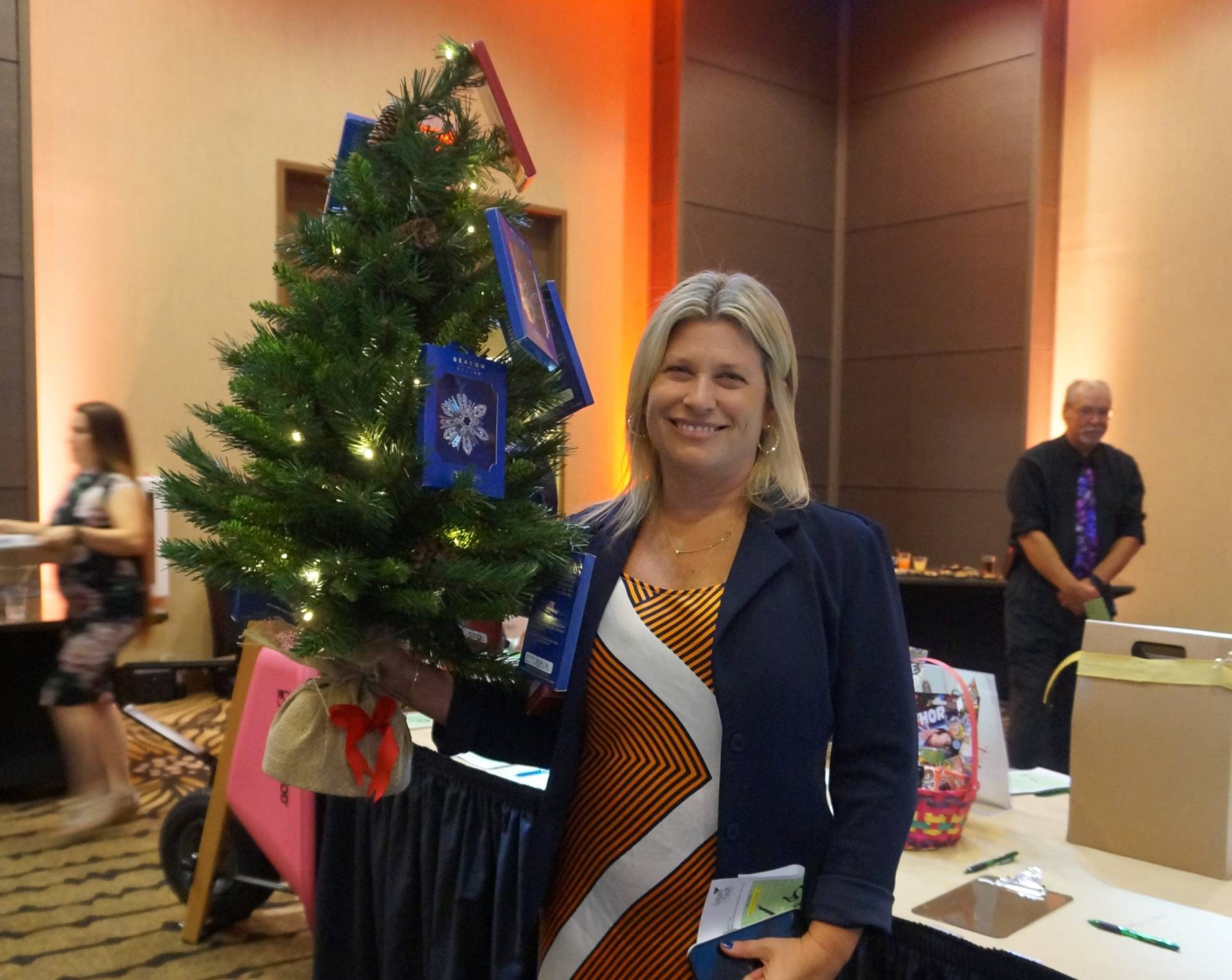 Amanda holding Christmas tree with assorted silver ornaments