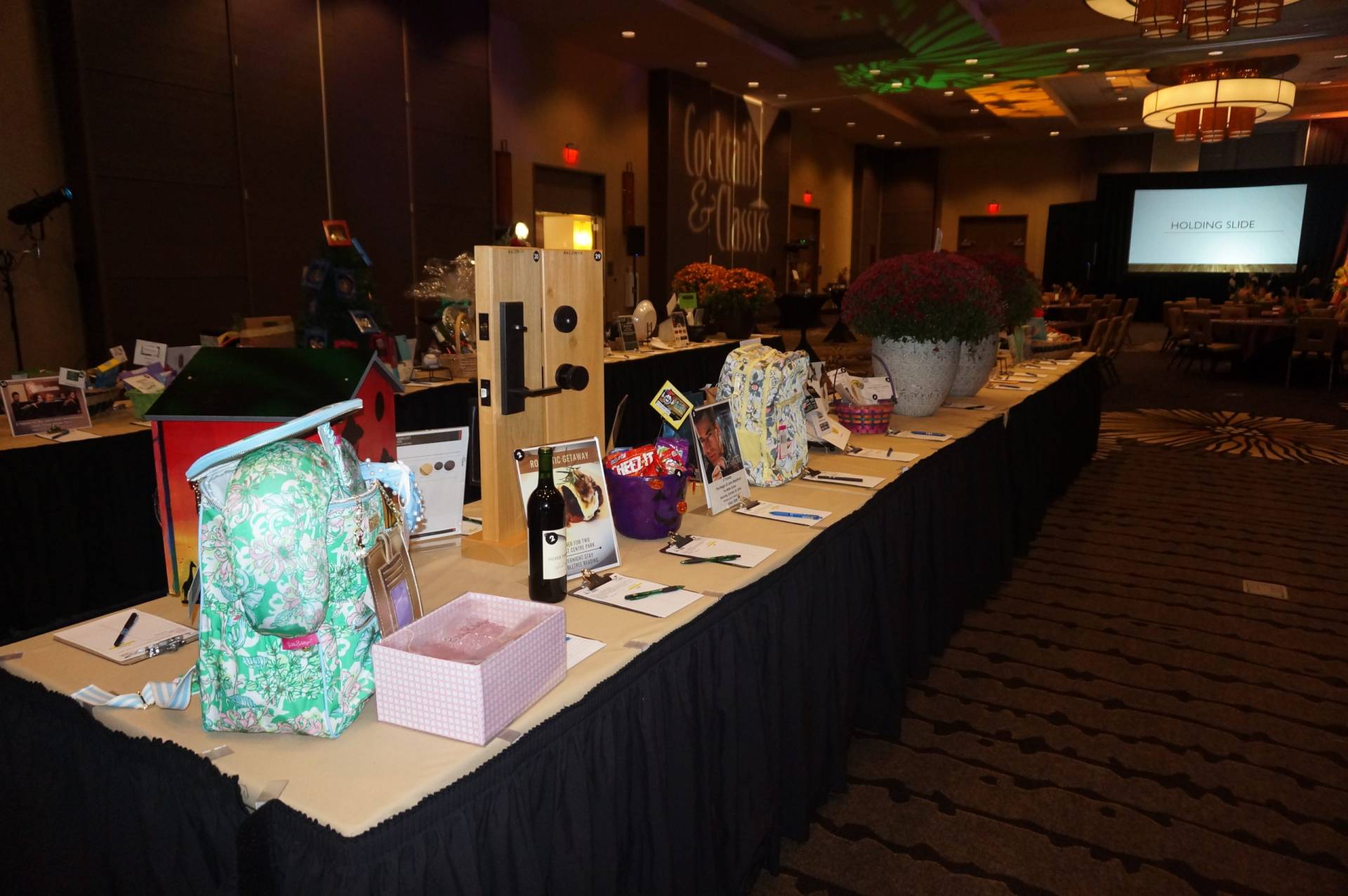 assortment of auction items on a table at cocktails and classics.